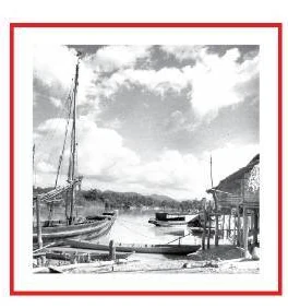 ภาพถ่ายขาวดำ เรือใบและเรือประมงจอดที่ท่าน้ำริมแม่น้ำ